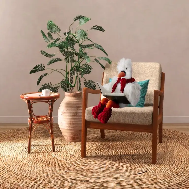 Yazou lit dans un fauteuil, foulard et chaussettes rouges, à côté d'une plante et d'un guéridon en rotin.